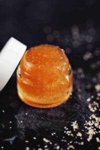 Homemade DIY sugar lip scrub in a small jar with honey and natural oils